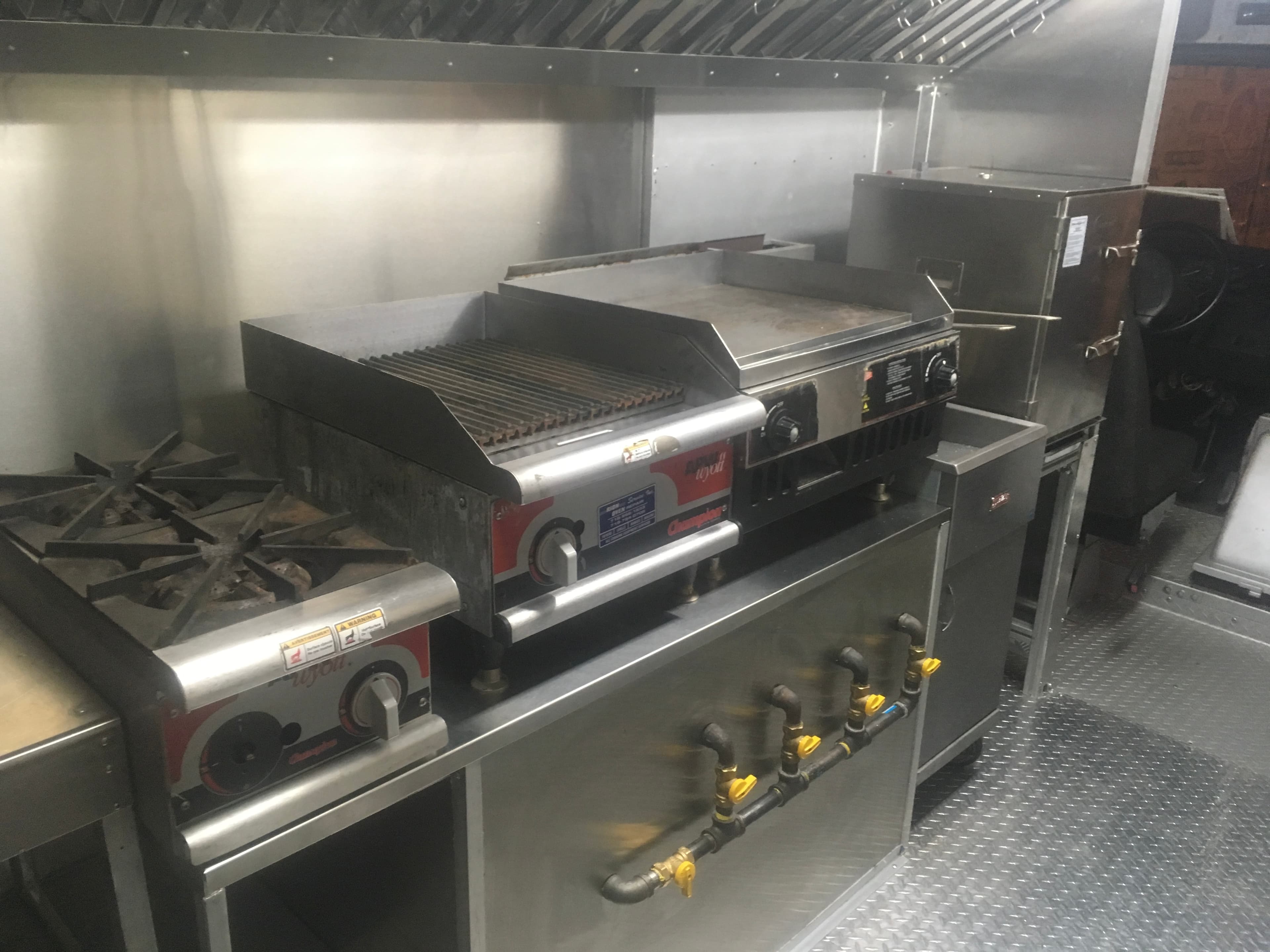 Interior kitchen build — flat top, burners, hood system